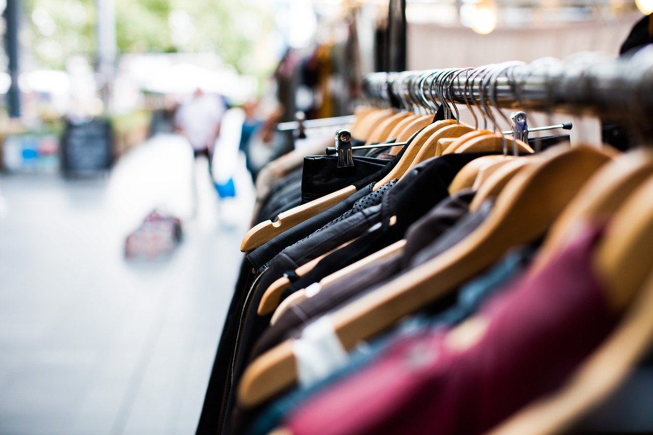 bourse aux vetements des cintres rangés sur une barre